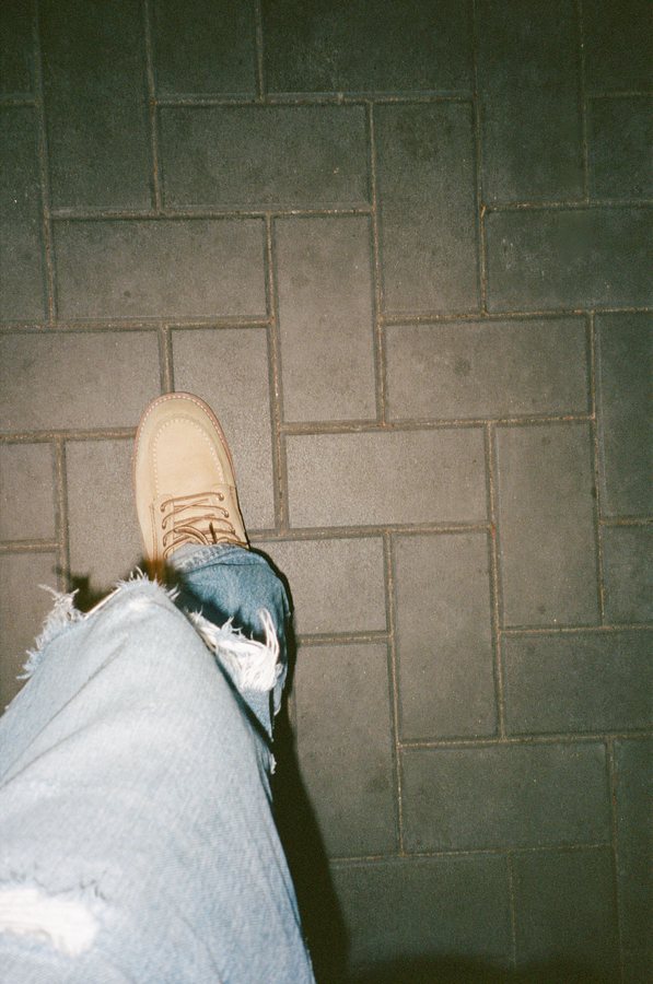 Jordan’s sneaker and jeans on a paved floor, shot from above